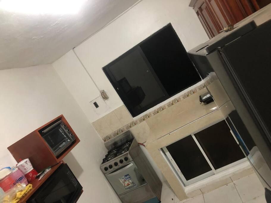 cocina pequeña con fogones y microondas en Apartamento segundo piso B en Santa Cruz de Barahona