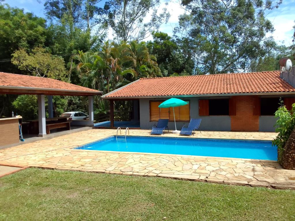una piscina frente a una casa en Sítio Encontro das Águas Brotas, en Ibirapuera