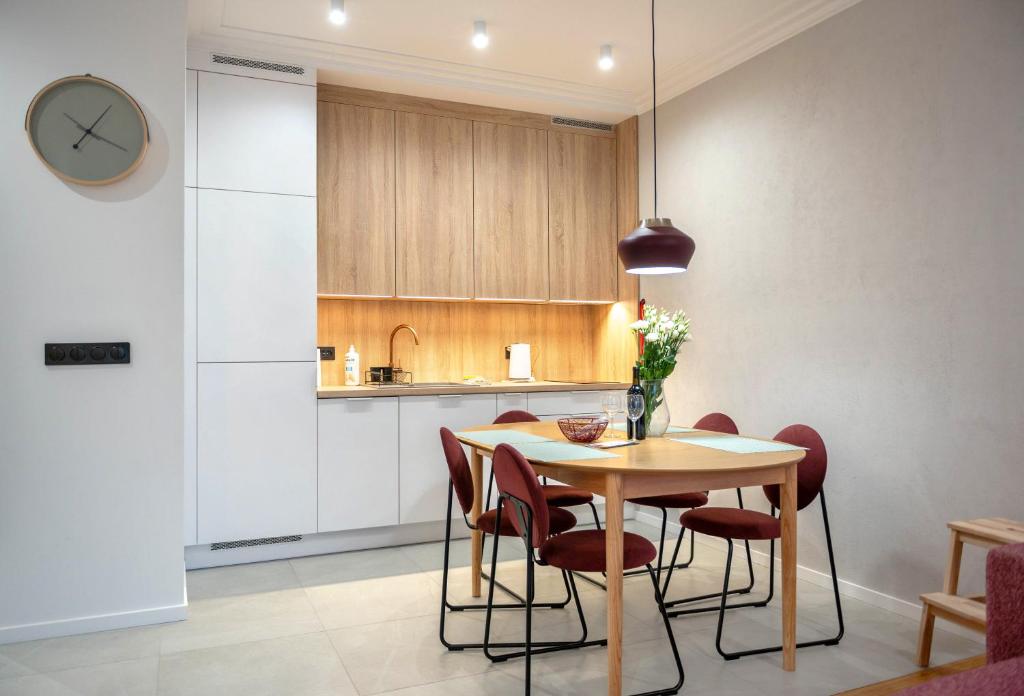 a kitchen and dining room with a table and chairs at Raspberry apartment and SPA in Dziwnów