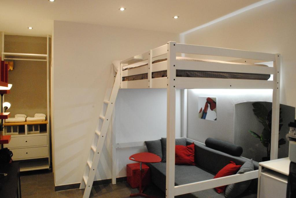 Cama elevada en habitación con sofá en Appartamento Arco della Pace, en Milán