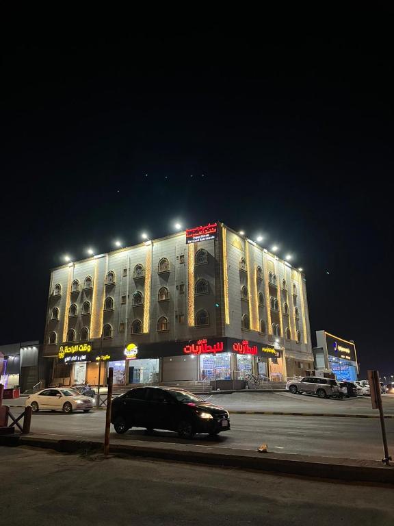 un coche aparcado delante de un edificio por la noche en هابي دريم للشقق المخدومة en Ukaz