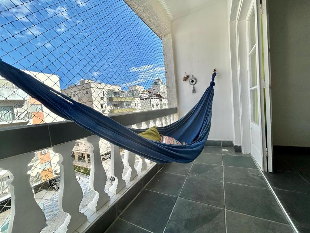 a hammock in a room with a window at apartamento fofo Astúrias in Guarujá