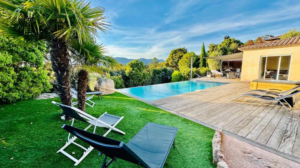 a yard with chairs and a swimming pool at Villa Porto-vecchio 4 chambres avec piscine in Porto-Vecchio