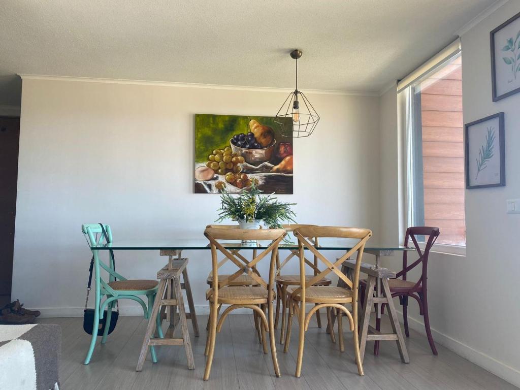 una mesa de comedor con sillas y una pintura en la pared en Hermoso depa, en Puerto Varas