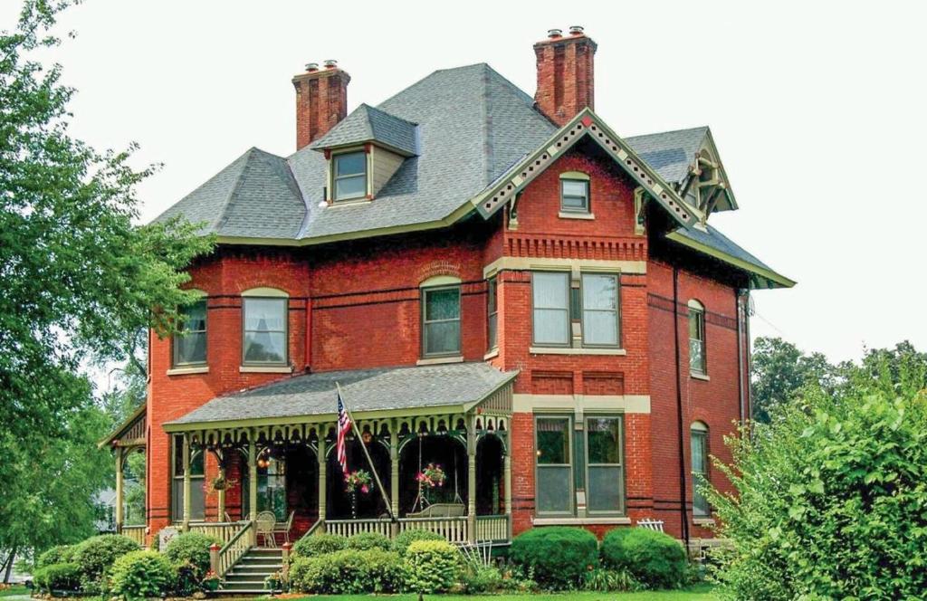 a large red brick house with a gray roof at Squiers 1882 in Maquoketa