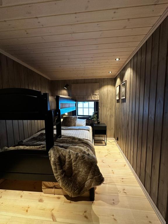 a bedroom with a bed in a room with wooden walls at Trysil Moderna Lodge in Trysil