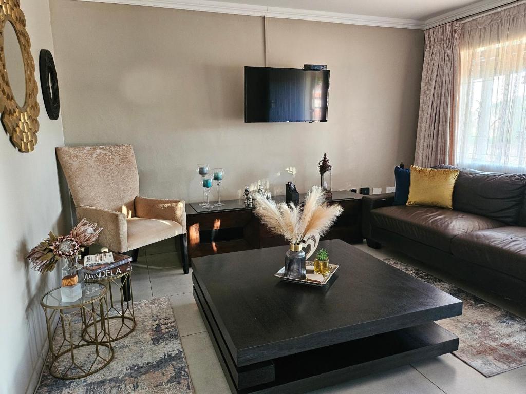 uma sala de estar com um sofá e uma mesa em TheeHost@1924 em Mmabatho