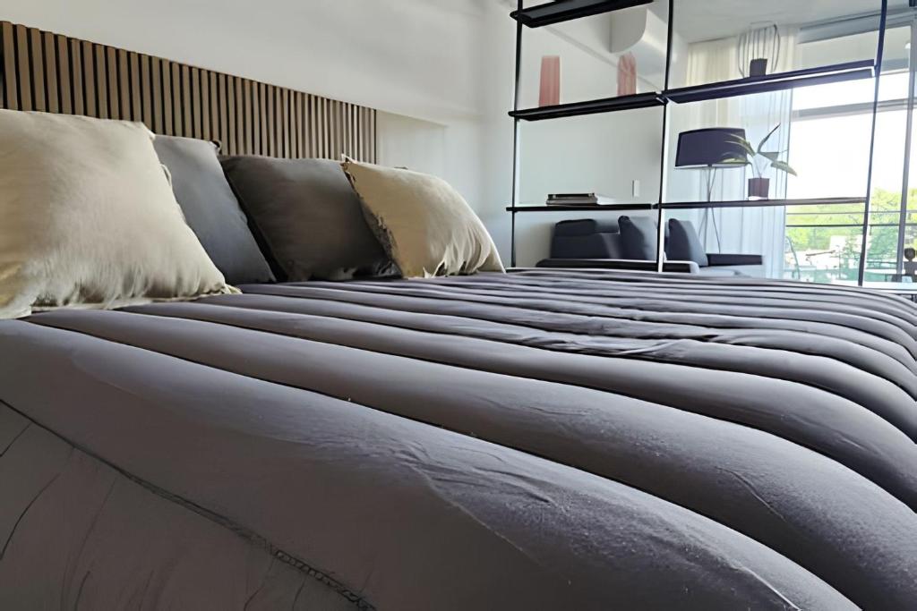 un grande letto con cuscini sopra in una stanza di Luxury and Modern Aptartment en Distrito Quartier a Buenos Aires