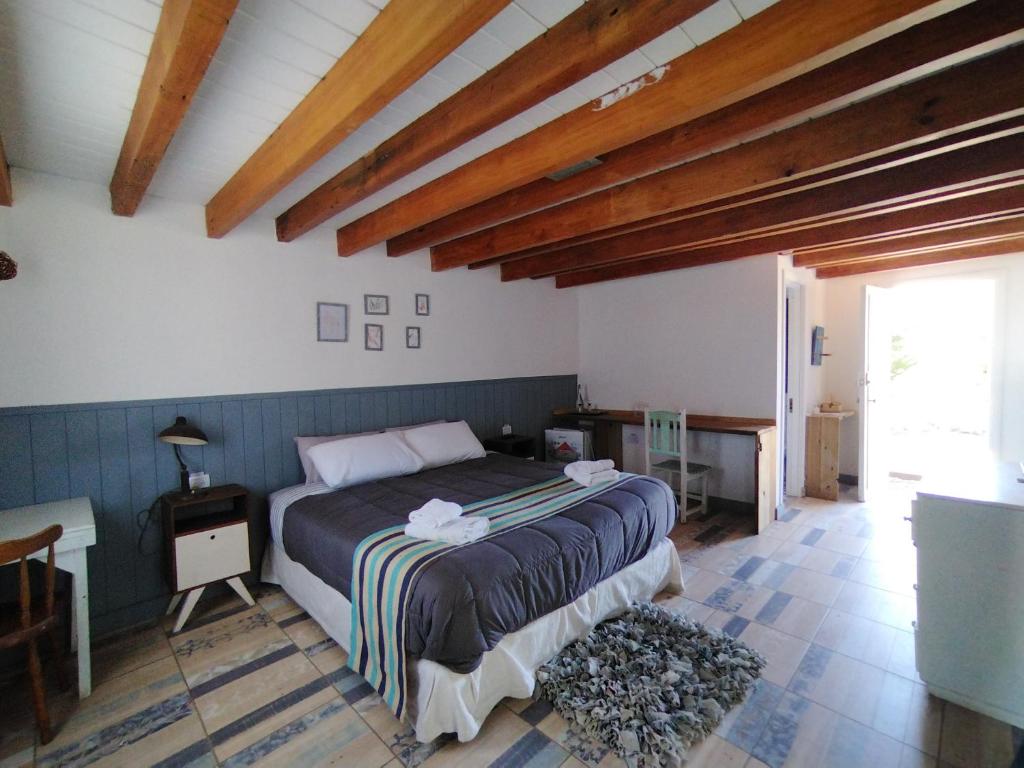 維亞梅立奎納的住宿－Mountain House Suites de montaña，一间带一张床的卧室,位于带木制天花板的房间内