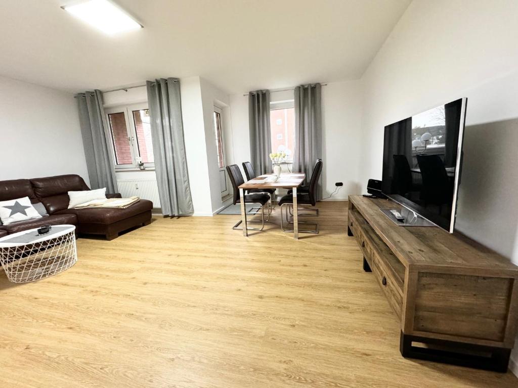 sala de estar con sofá y TV de pantalla plana en Traumhafte Ferienwohnung zentral, en Nordenham