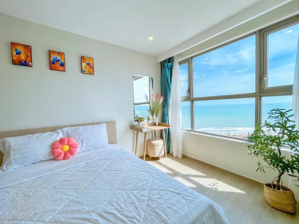 sypialnia z łóżkiem i dużym oknem w obiekcie The Song Balcony Apartment Vung Tau w mieście Vung Tau