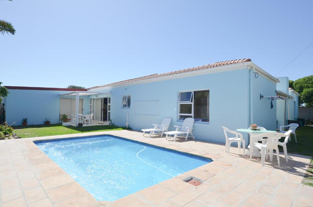 a house with a pool and a table and chairs at Family Tides in Yzerfontein