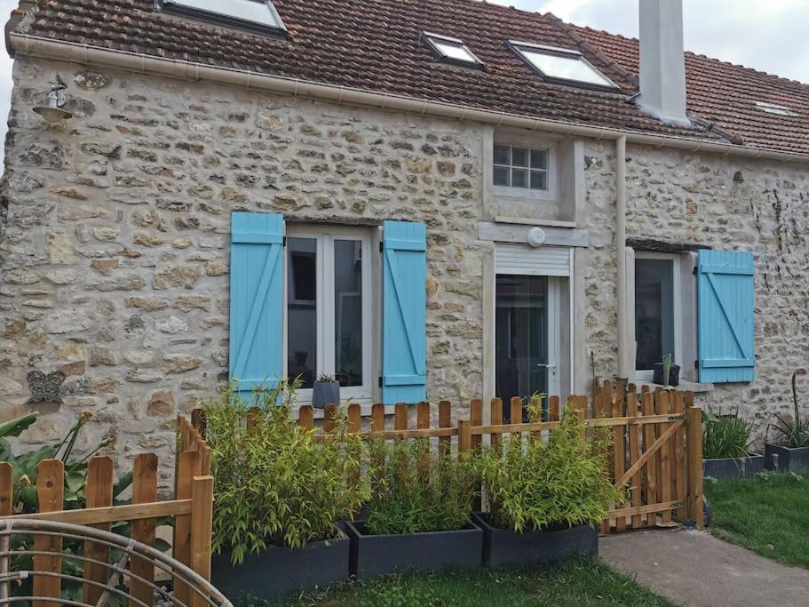 Ce cottage en pierre est doté de volets bleus sur les fenêtres. dans l'établissement Maison Moisson 4-6 personnes 2 chambres, à Moisson