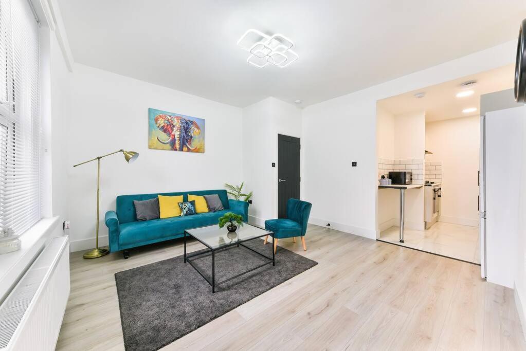 a living room with a blue couch and a table at Modern London Apartment with WIFI in Norwood