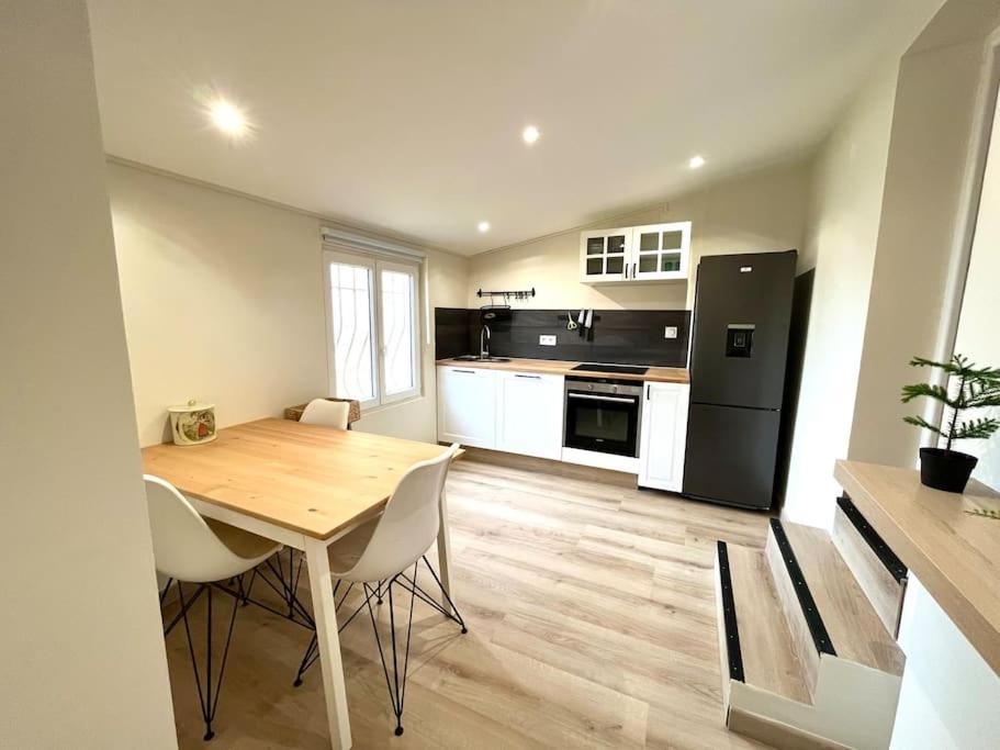 サン・ローラン・デュ・ヴァールにあるCharmant appart 35m² dans villaのキッチン(木製テーブル付)、ダイニングルーム