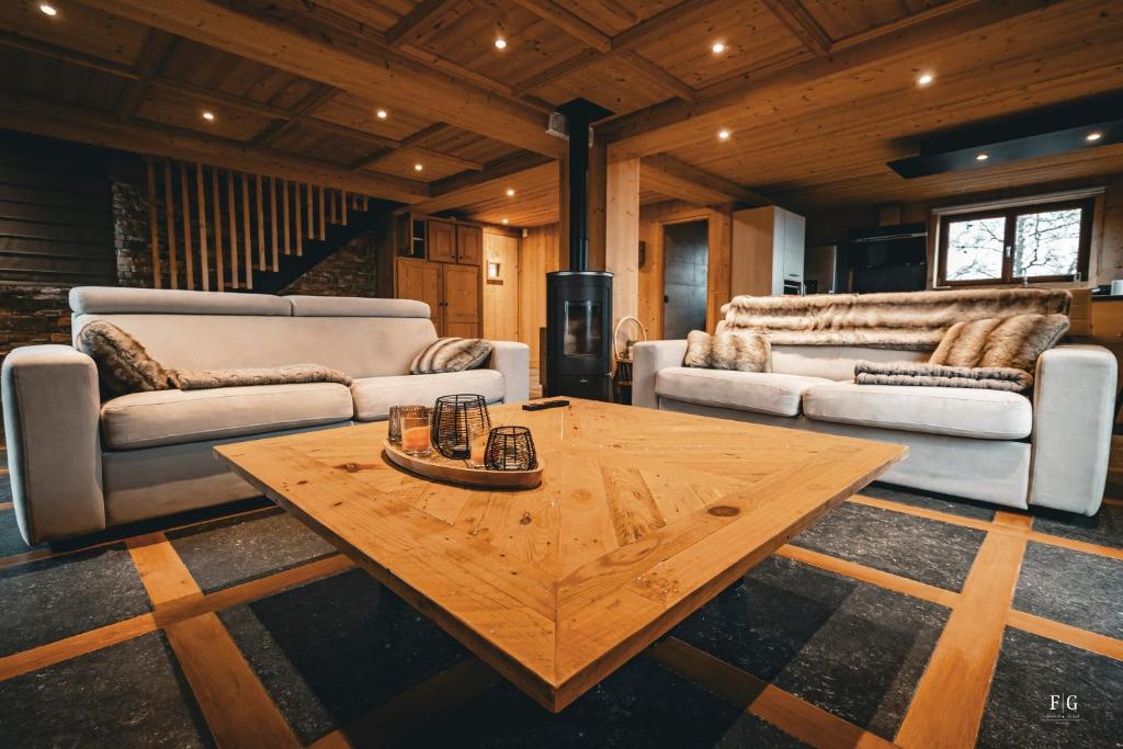 ein Wohnzimmer mit einem Couchtisch aus Holz und Sofas in der Unterkunft Chalet Mont Blanc - Conciergerie de la Yaute in Cordon