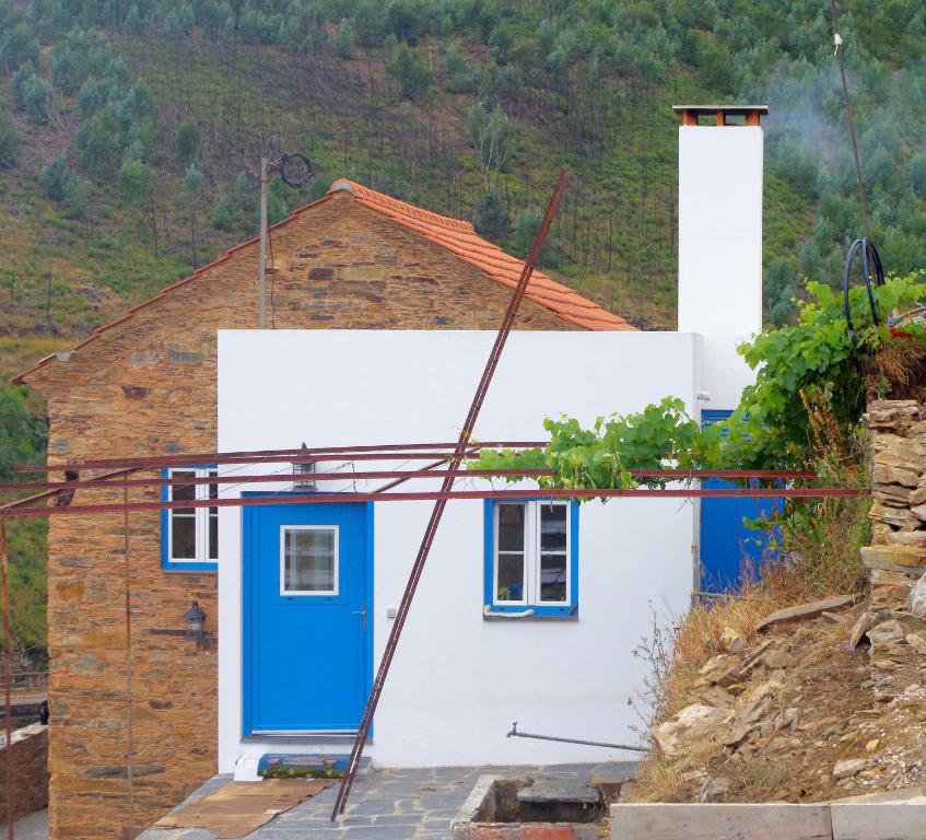 una casa con una puerta azul en una colina en Casas do Sinhel, en Chã de Alvares