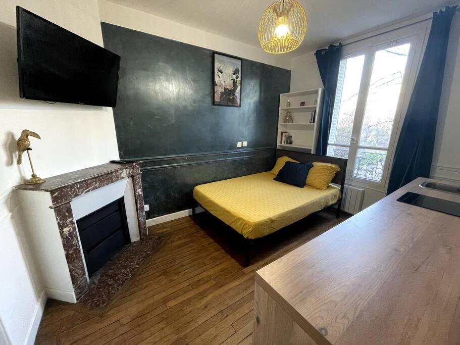 - un salon avec un lit et une cheminée dans l'établissement Studio Vintage : proche Paris, à Ivry-sur-Seine