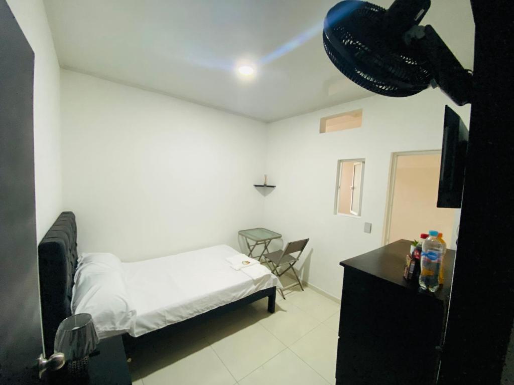 Schlafzimmer mit einem Bett, einem Schreibtisch und einem Tisch in der Unterkunft Alojamientos Z.V in Tumaco