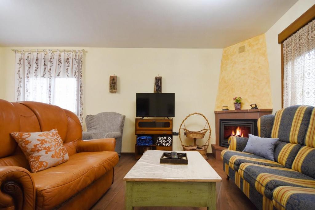 sala de estar con sofá y chimenea en Casa Las Torres, en Navas de Oro