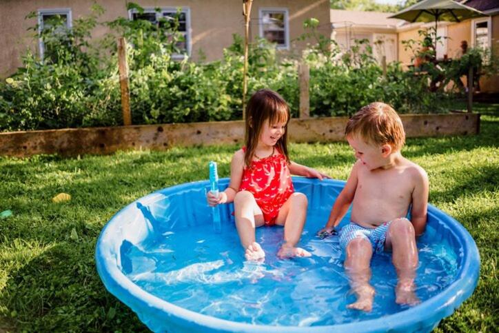 chłopiec i dziewczynka siedzący w basenie z wodą w obiekcie Noble Luminous Accommodation & Tours w mieście Lafrenz Township