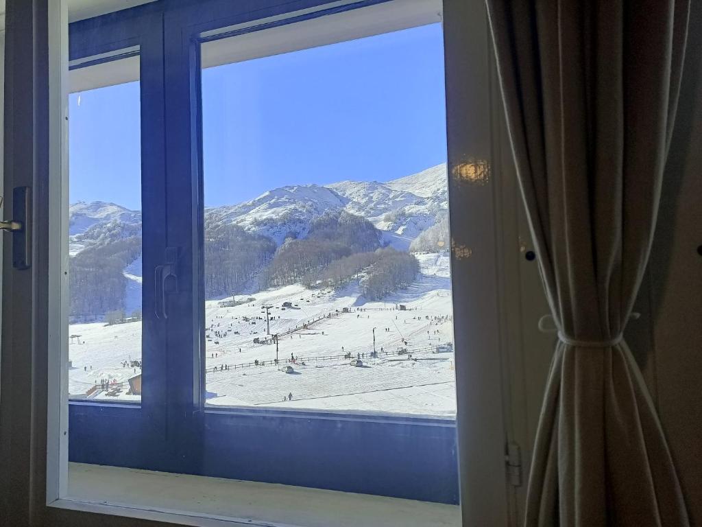 ein Fenster mit Blick auf eine Skipiste in der Unterkunft Monte Miletto Apartment in San Massimo
