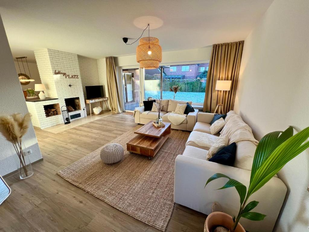 uma sala de estar com um sofá branco e uma mesa em Appartement „Zum Weißen Hahn“ em Bad Zwischenahn