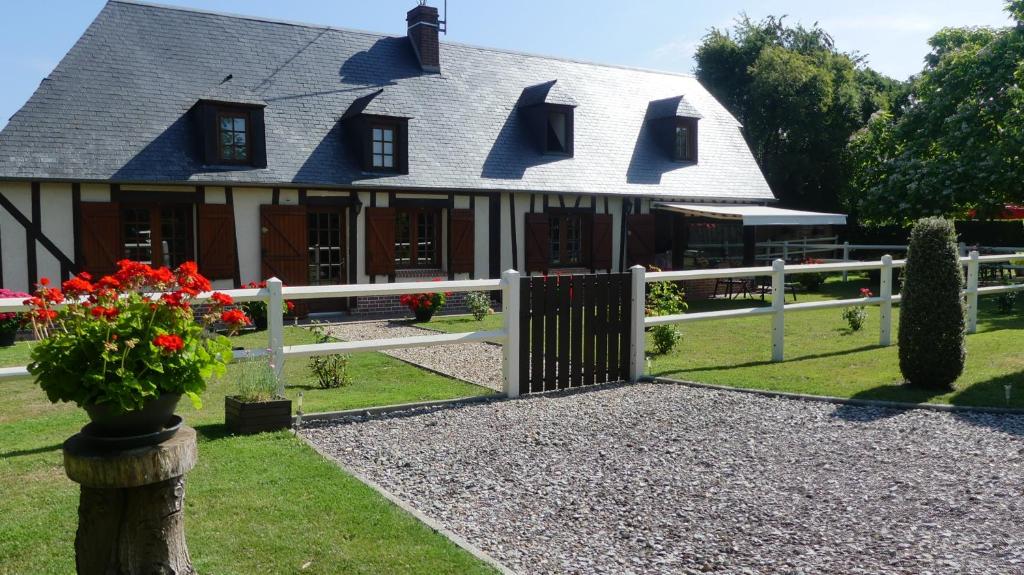 una casa con una valla y flores en el patio en Le Pressoir, en Beaumesnil