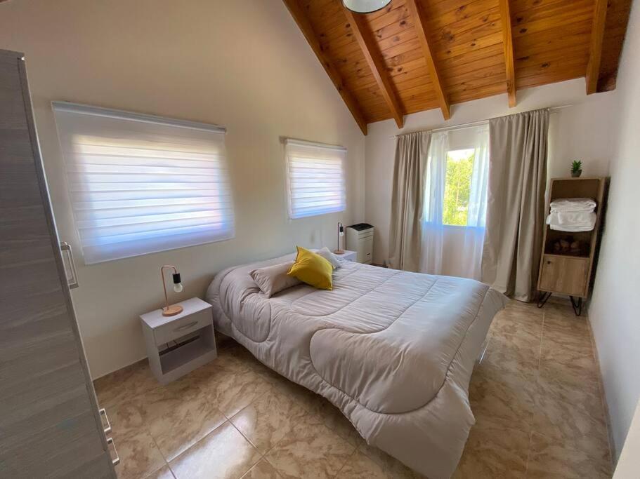 ein Schlafzimmer mit einem Bett mit einem gelben Kissen darauf in der Unterkunft Alta Montaña Apart in El Chalten