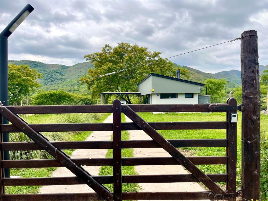 um portão de madeira que leva a uma casa num campo em Casa Quincho ROMA em Salta