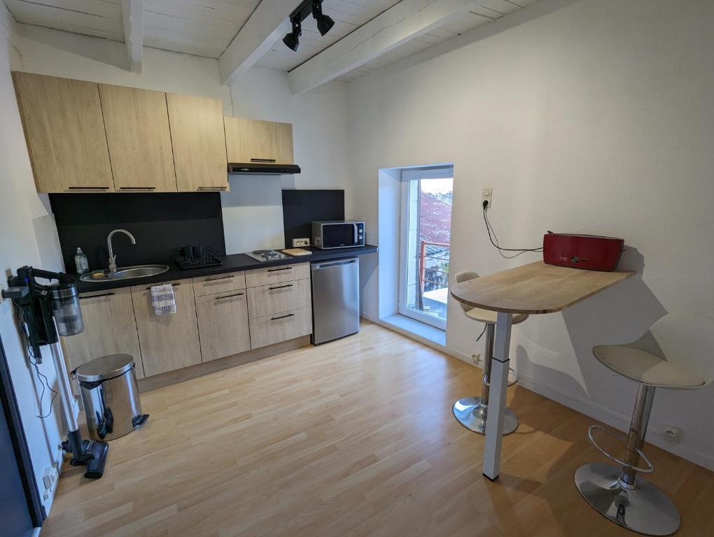 eine Küche mit einem Tisch in der Mitte eines Zimmers in der Unterkunft La maison de Joe in Beaumont