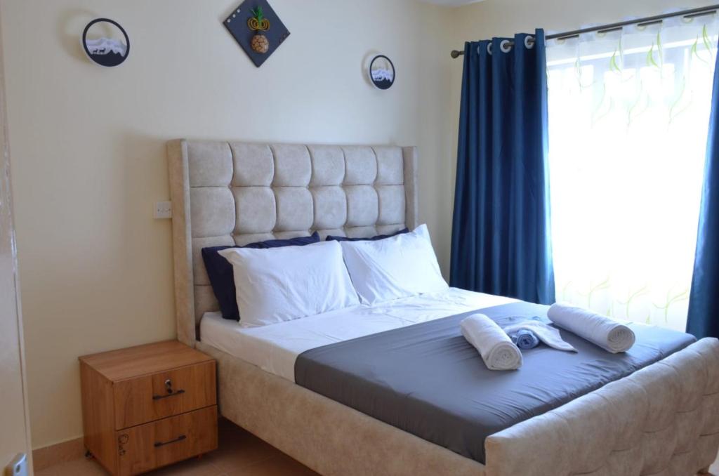 a bedroom with a large bed with a large window at Bright Box 1 br near JKIA in Nairobi