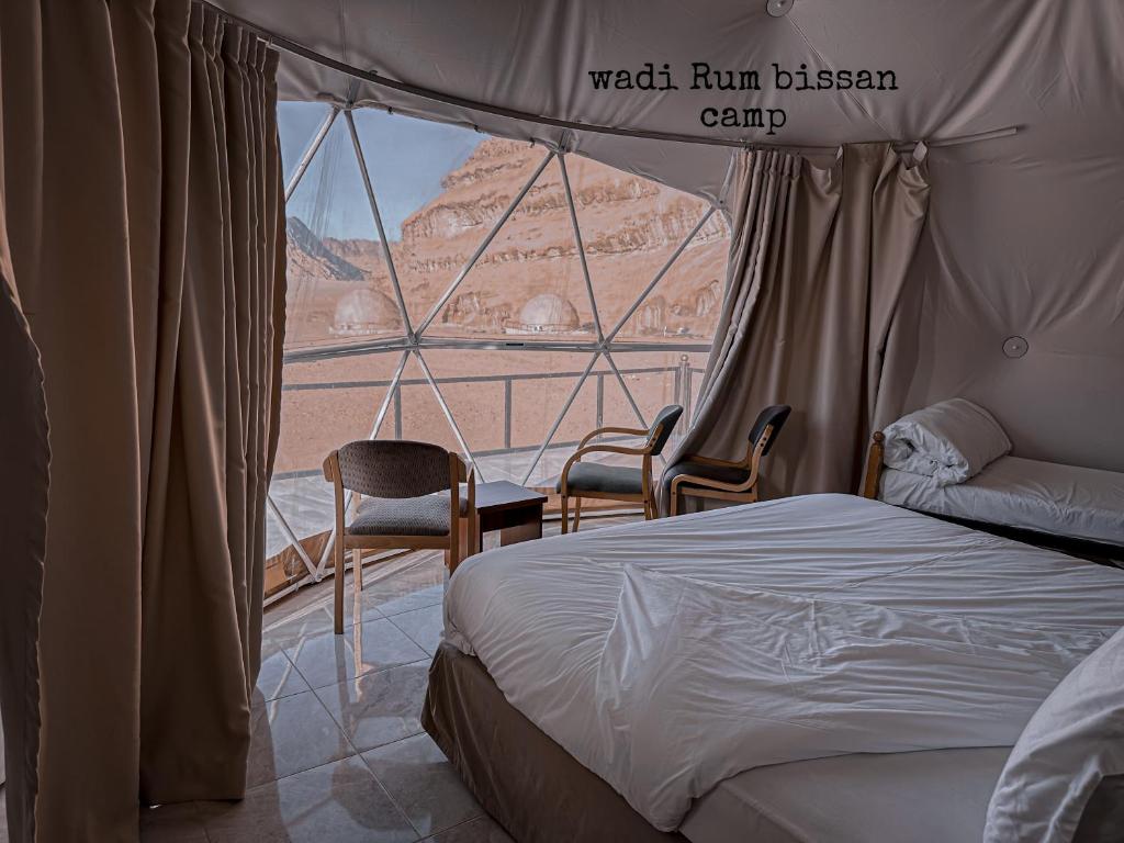 1 dormitorio con cama y vistas al desierto en wadi Rum bissan camp en Disah