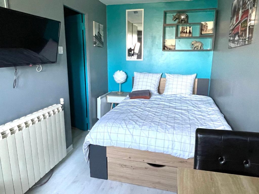 1 dormitorio con 1 cama y TV de pantalla plana en Studio cosy indépendant avec Jardin à Osny proche Cergy Pontoise en Osny