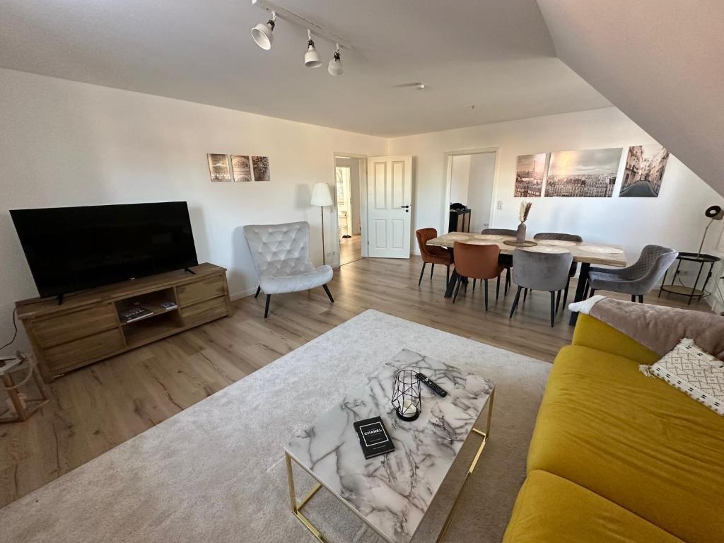 uma sala de estar com um sofá e uma sala de jantar em Whg 5 Traumhafte Ferienwohnung in Scharbeutz - für die ganze Familie! em Scharbeutz