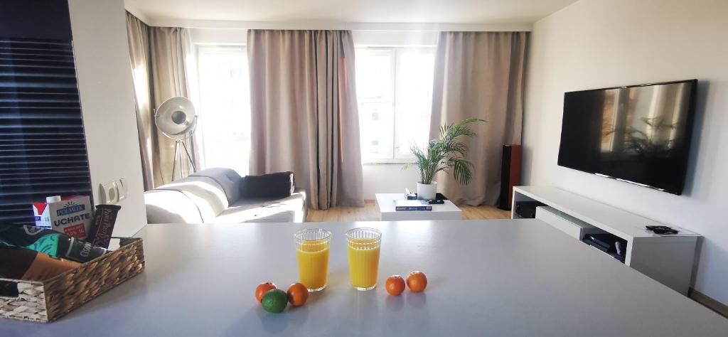two glasses of orange juice on a table in a living room at Sweet Lime Apartments Kaszubska 57m2 in Wrocław
