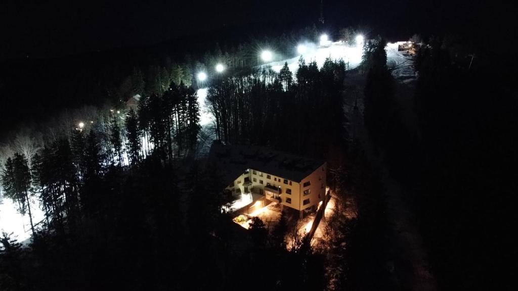 eine Luftansicht eines Gebäudes in der Nacht mit Lichtern in der Unterkunft Forest View Apartment in Hočko Pohorje