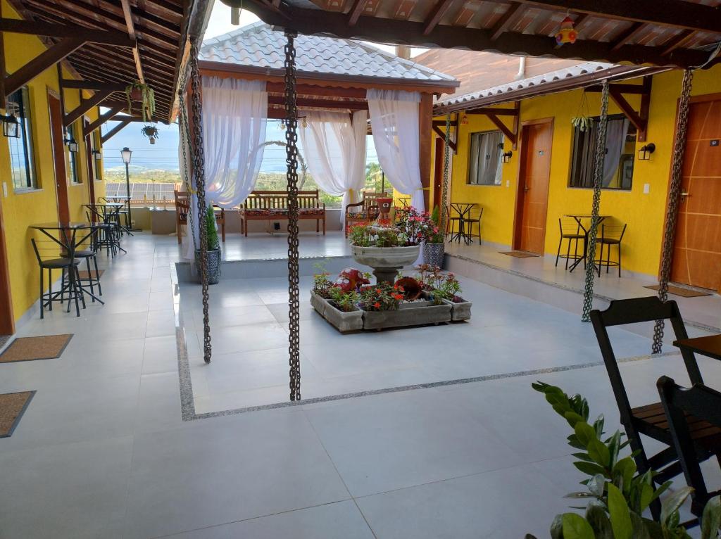 - une terrasse avec une table, des chaises et des fleurs dans l'établissement Hospedagem Encantos da Serra, à Itatiaia