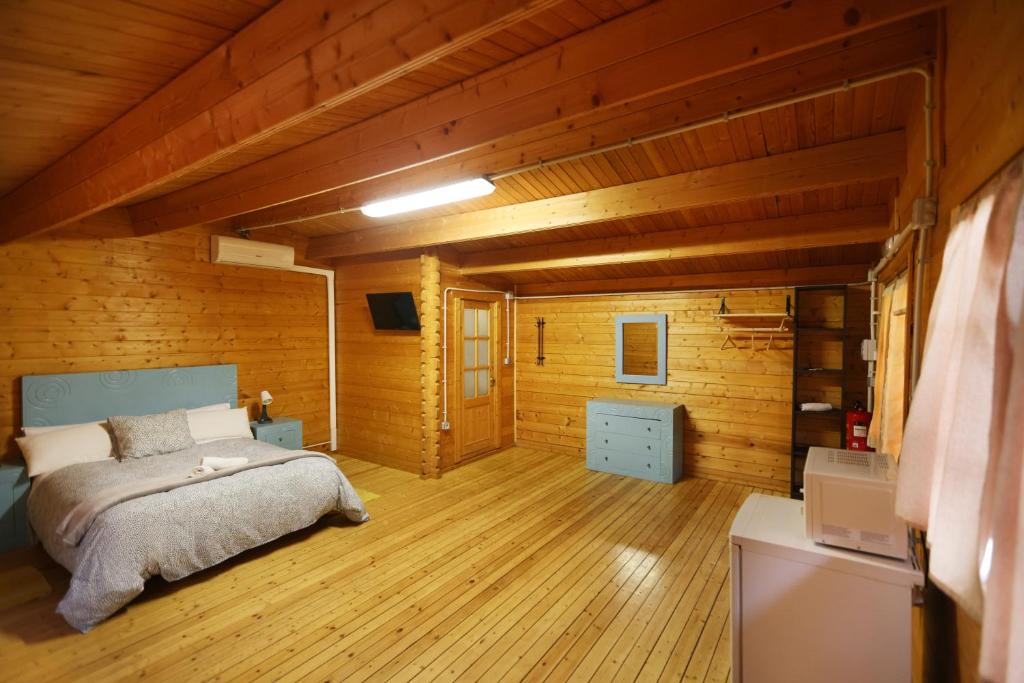 a bedroom with a bed in a room with wooden walls at El Bosque de Ribera in Escalona