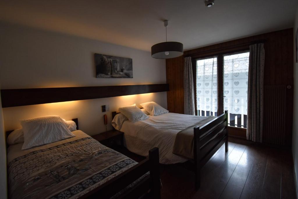 Postel nebo postele na pokoji v ubytování Hôtel Le Chinfrey