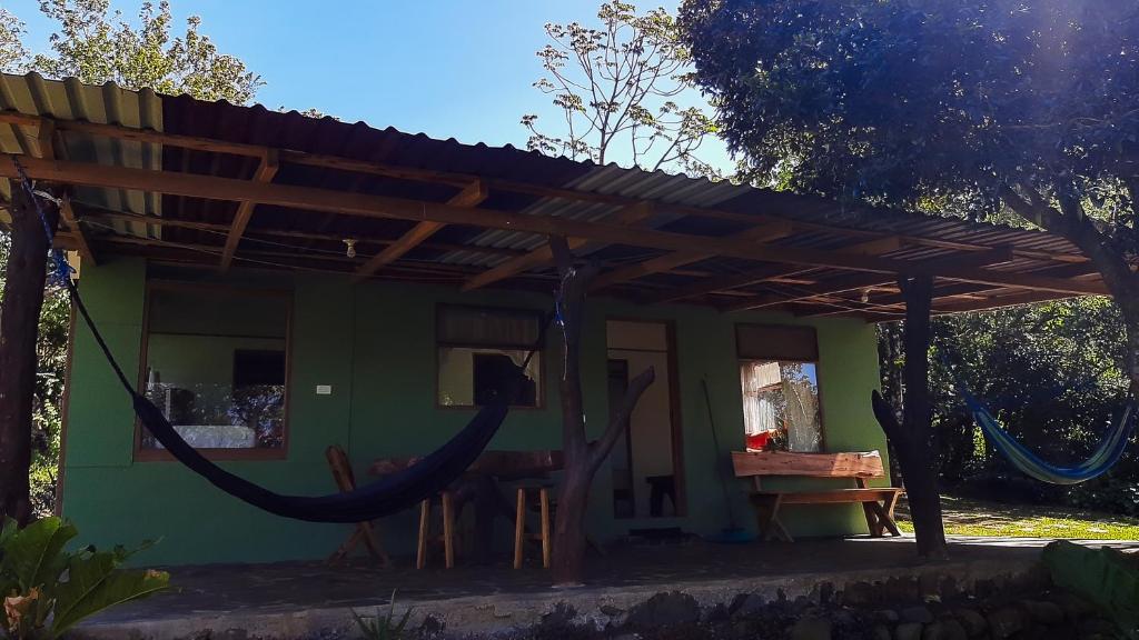 una casa verde con pérgola de madera en Granja los Campesinos, en Monteverde