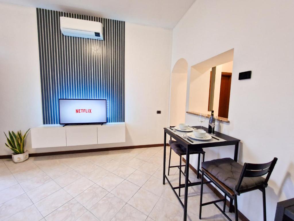Zimmer mit einem Tisch und einem TV an der Wand in der Unterkunft MONZA CENTRO 5 Minuti POLICLINICO STADIO MONZA in Monza