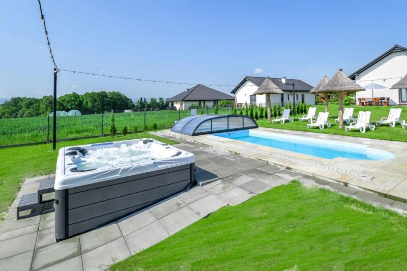 een zwembad met een hot tub in de tuin bij Słoneczne Wzgórze Zator in Zator