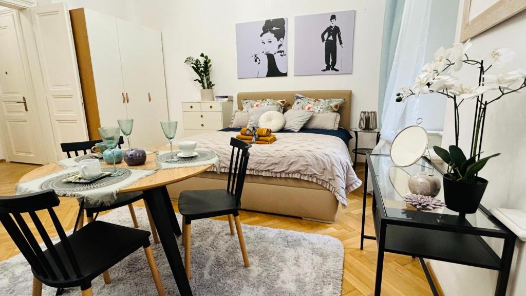 1 dormitorio con 1 cama, mesa y sillas en Kampa park Apartment, en Praga
