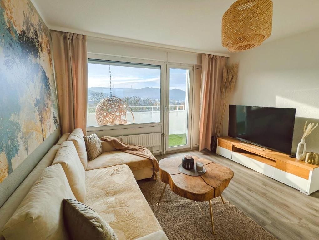 een woonkamer met een bank en een groot raam bij Wohnung mit Balkon und Aufzug in Hagen