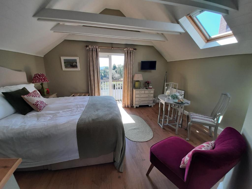 Un dormitorio con una cama grande y una ventana en The Green Room en Midhurst