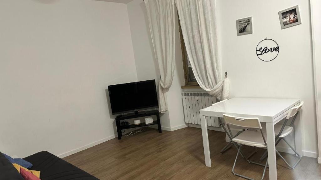 ein Wohnzimmer mit einem weißen Tisch und einem TV in der Unterkunft Casa Gemelli Roma in Rom