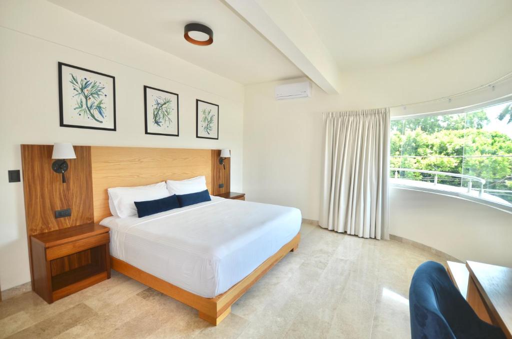 a bedroom with a white bed and a balcony at Hotel Plaza Rioverde in Río Verde