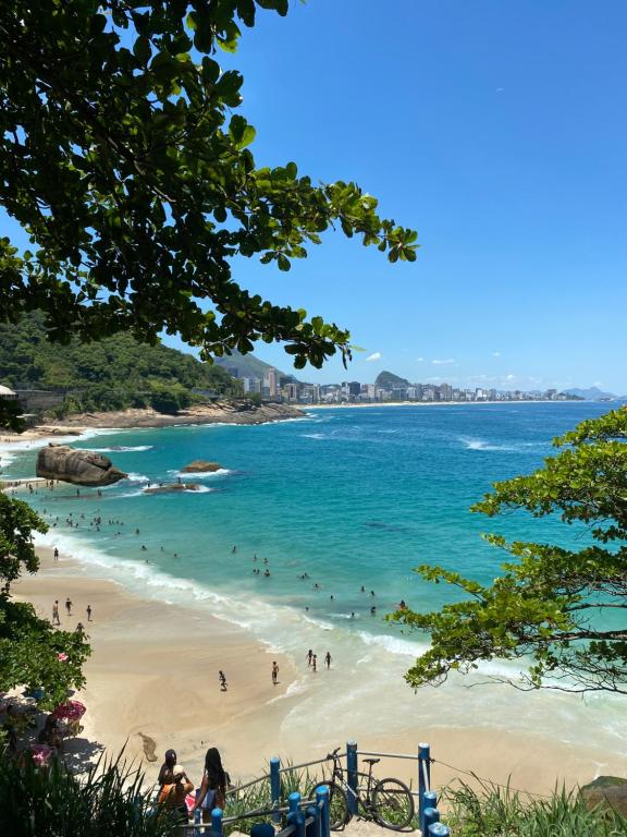 - une vue sur la plage avec des gens dans l'eau dans l'établissement Quarto Privativo no Vidigal, à Rio de Janeiro