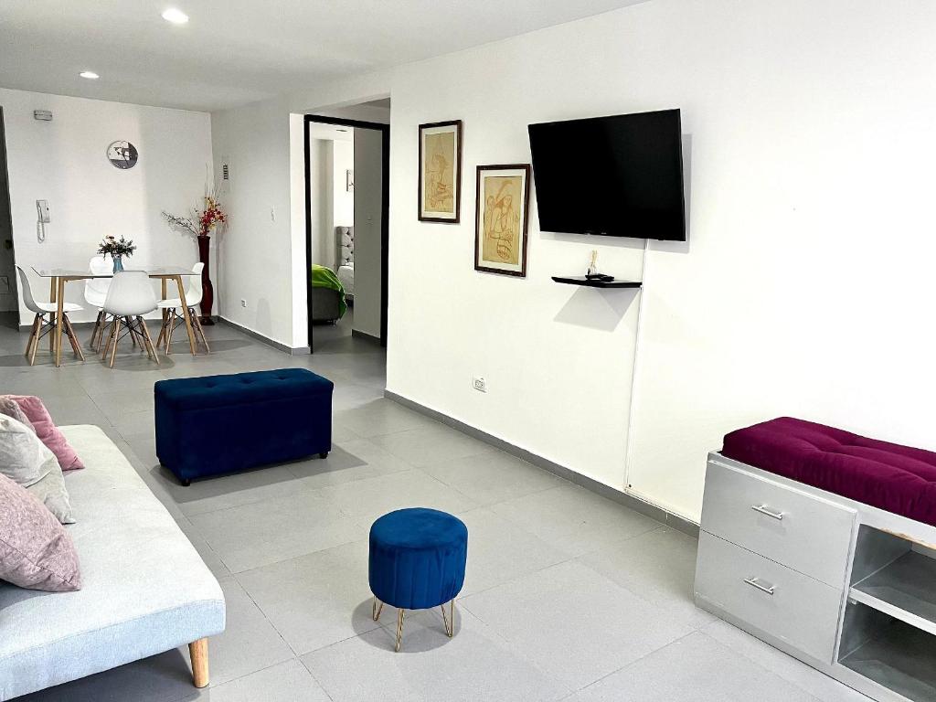 a living room with a couch and a tv on a wall at Apartamento Comodo, Cerca al Rio Guatapuri in Valledupar